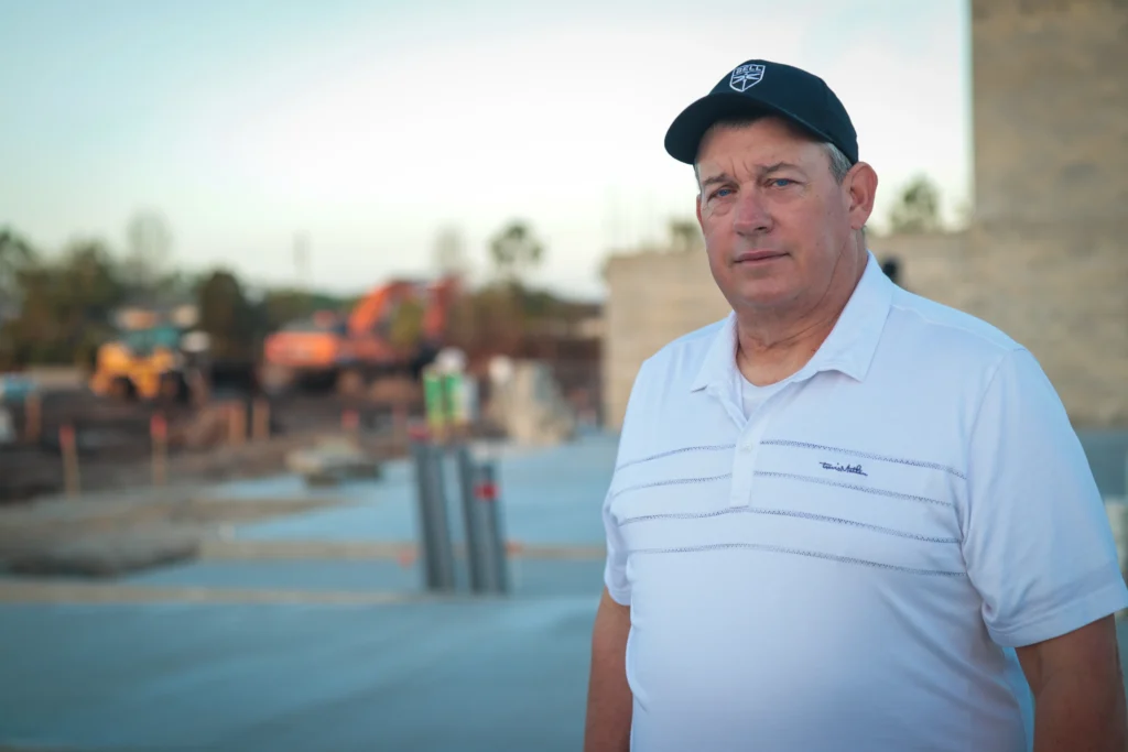 Portrait of Mike Miller, founder of ILCC, at an active Florida construction site, representing 30+ years of hands-on land development experience.